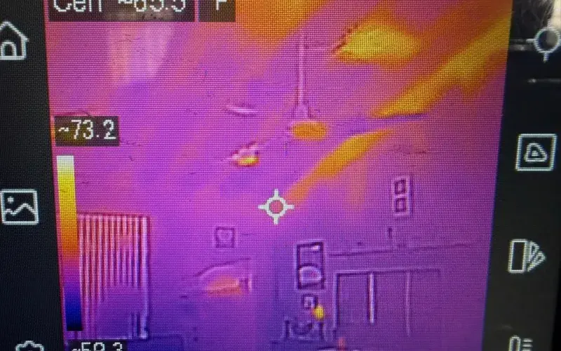 Thermal imaging camera screen showing temperature differentials inside a home